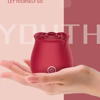Vibrator clitoridian cu încărcare magnetică, în formă de trandafir, de culoare roșu intens, ținut în mână, cu livrare gratuită și ambalaj discret.